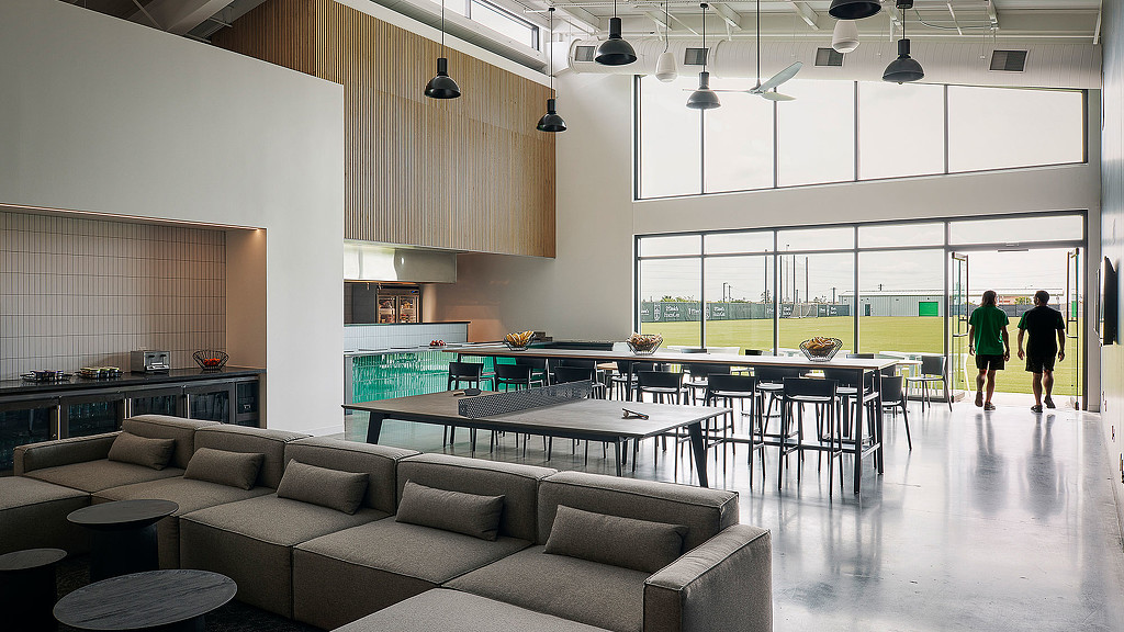 A large room with a large glass wall and a large table with chairs.